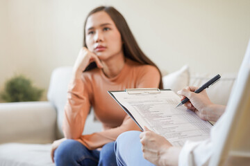 Psychology, depression. Sad, suffering asian young woman consulting with psychologist, psychiatrist while patient counseling mental with doctor woman taking notes at clinic. Encouraging, therapy.