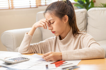 Financial owe asian young woman, girl sitting suffer, stressed and confused by calculate expense from invoice or bill, have no money to pay, mortgage or loan. Debt, bankruptcy or bankruptcy concept.