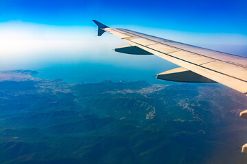 Fototapeta premium View from the airplane window at a beautiful blue clear sky and the airplane wing