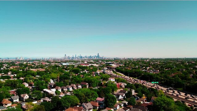 4k slow flight towards interstate above chicago suburbs while having chicago always on view, many trcuks, buses, taxi commuting on interstate I94