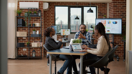 Team of business people working on financial analysis with data statistics in digital tablet and laptop. Office employees meeting to brainstorm ideas and do teamwork on strategy plan.