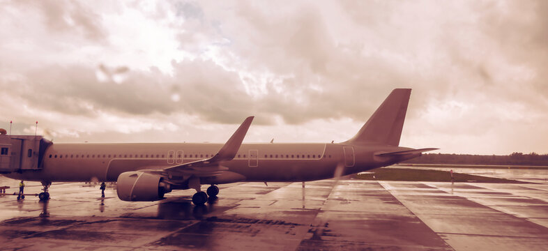 A passenger plane is preparing to take passengers on board. Panoramic side view.