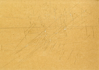 Highly detailed brown paper board texture with many knife cut marks and scratches worn down, used...