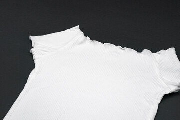 close up to flat White knitwear tshirt shape on black background with studio light.