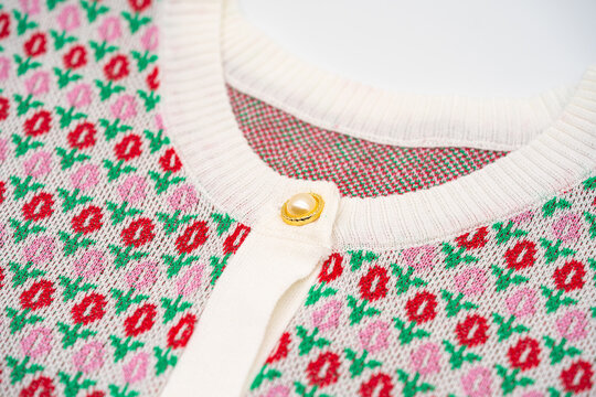 Close up to knitting flower pink and red sweater pearl gold circle buttons on the top of tshirt sweater.