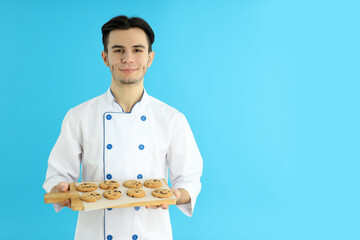Concept of cooking, young male chef on blue background