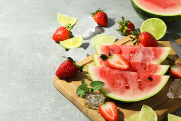 Fresh and juicy fruits with ice on gray textured background