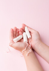 Tampons in female hands. Lack of feminine hygiene products