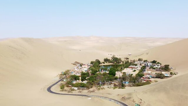 Huacachina, Peru: Aerial drone footage of the stunning Huacachina oasis in the sand desert near Ica in Peru in south America. Shot with a upward and tilt down motion. 