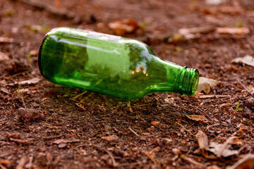 an empty green glass bottle on the ground