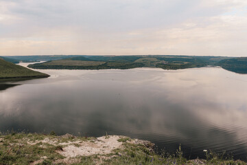 Obraz premium The landscape of Bakota Bay on the Dniester river, Ukraine. The banks of a large river. A calm smooth water view.