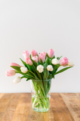 Bouquet of delicate pink and white tulips in a vase.