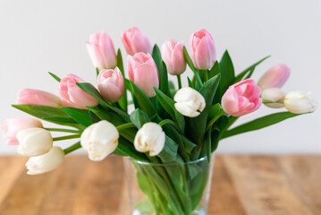 Bouquet of delicate pink and white tulips in a vase.