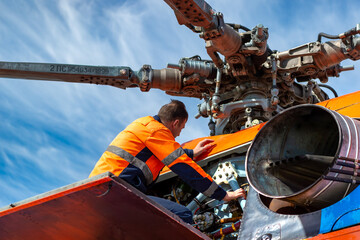 Technician - ground personnel at the airport checks the engine of the helicopter. Helicopter...