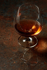 Brandy is in broken glass on a rusty background.