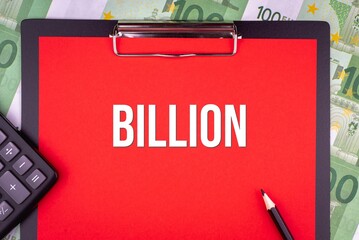 BILLION - word on the background of money, a notepad and a pencil with a calculator. Business concept (copy space).