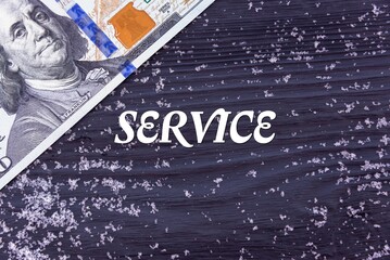 SERVICE - word (text) on a dark wooden background, money, dollars and snow. Business concept (copy space).