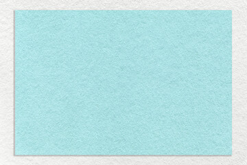 Fototapeta premium Texture of craft light blue color paper background with white border, macro. Structure of vintage turquoise cardboard.