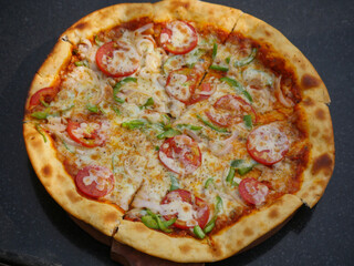 Vegetarian cheese Pizza in india topped with tomatoes, capsicum and onion. Indian veg pizza