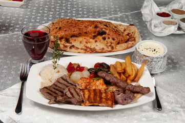 There is shish kebab, pita bread and fruit juice on the dining table. Grill made of chicken and lamb.