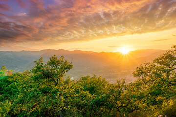 graet highland landscape with scenic view from mountain to below to a walley with majectic mountains and scenic cloudy sunset on background