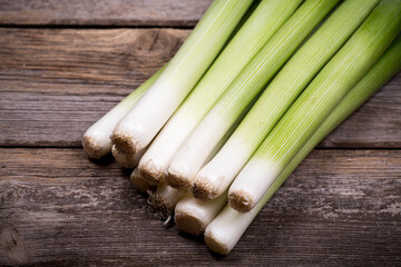 Baby leeks  on an old wood background
