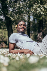 Naklejka na ściany i meble African american gay young man in a flowered park