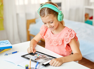 education, school and distant learning concept - happy student girl in headphones with tablet...