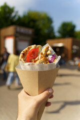 Greek street food gyros in hand. Greek and Mediterranean cuisine with meat in pita.