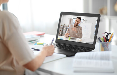 education, online school and distance learning concept - student woman with teacher showing wind turbine model on laptop computer screen having video call at home