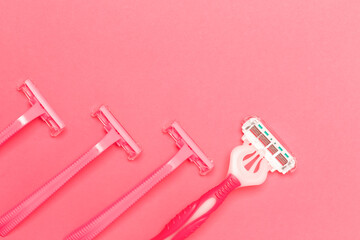 Legs Hygiene Concepts. Close-up of Four Various Female Pink Disposable Razors Shavers Placed Together Over Trendy Pink Coral Background.