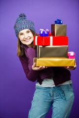 Holiday Ideas. Winsome Laughing Caucasian Adult Female in Seasonal Warm Clothing Posing with Stack of Wrapped Present Gift Boxes And Smiling