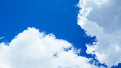background of white thick cumulus clouds on a blue sky on a sunny bright day