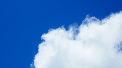 background of white thick cumulus clouds on a blue sky on a sunny bright day