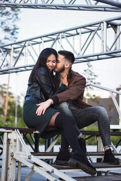 Couple of young man and woman in love having fun together at steel construction at romantic dating, sensual relationship and desire of lovers, candid lifestyle, vertical image with industrial style