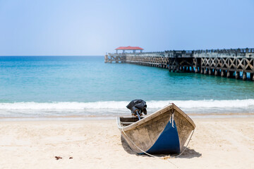 Fototapeta na wymiar Fishing boat on the beach with Concrete pier on background, travel to asia, tropical island