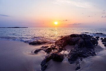 Fototapeta na wymiar Sunset on tropical island in south of Thailand, peaceful rock beach with beautiful sunset