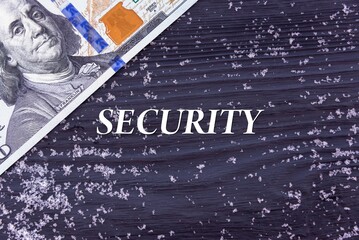 SECURITY - word (text) on a dark wooden background, money, dollars and snow. Business concept (copy space).