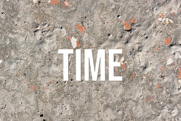 time - word on concrete background. Cement floor, wall.