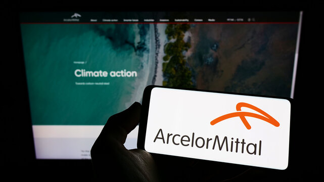 Stuttgart, Germany - 06-12-2022: Person holding cellphone with logo of steel company company ArcelorMittal S.A. on screen in front of business webpage. Focus on phone display.
