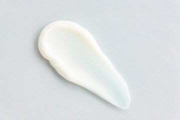 Trendy presentation of face cream. Textured strokes of cream on gray background. Skin care product.