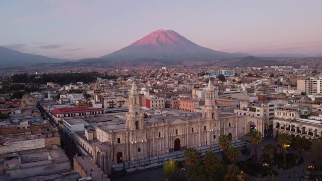 Arequipa, Peru: Aerial drone footage of the famous Plaza de Armas in Arequipa colonial old town with the Basilica Cathedral and the Misti and  Chachani  volcano at sunset in the Andes mountain range