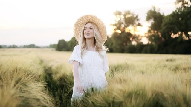 Young woman enjoying summer nature at sunset in wheat field, concept of harmony woman and nature, healthy lifestyle.