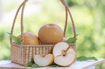 Snow pear fruit in basket, Fresh Nashi pear or Korean pear fruit in the basket on green bokeh background. 