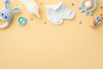 Baby accessories concept. Top view photo of knitted bunny rattle toy blue teether milk bottle tiny...