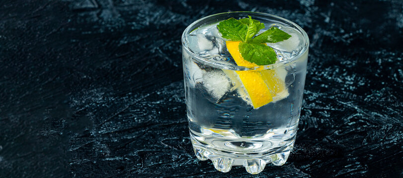 banner with serving mojito in glass. drink with lemon, mint, soda and ice on a black and white background. soft focus. refreshing and chilling drink in hot weather