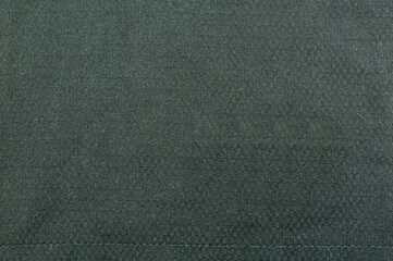 Texture - dark fabric with a thread at the bottom from a sewing machine.
