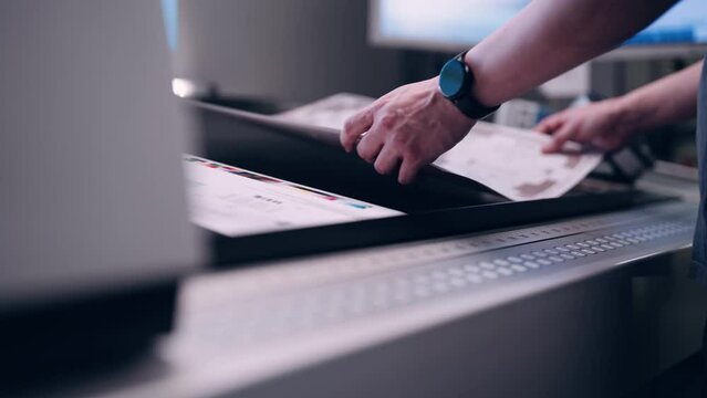 A worker in the printing house checks the quality of the printed packaging.