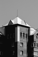 Black and white image of a residential building with a roof