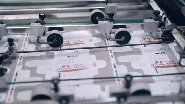 A cutting machine in a printing shop cuts printed packaging.